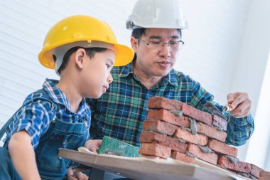 Küçük çocuk kendi yorumundan tuğla duvar örmeyi öğreniyor.