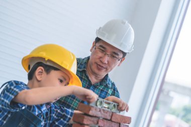 Küçük çocuk kendi yorumundan tuğla duvar örmeyi öğreniyor.