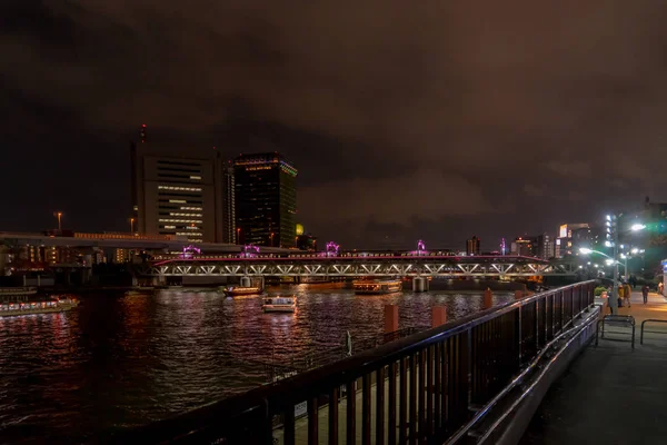 Loď cestuje po řece Sumida s mostem Asakusa v ba — Stock fotografie