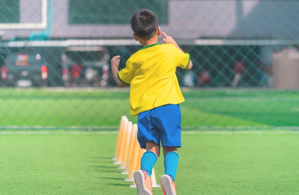 Soccer Boy si allena da solo con il cono sul terreno di allenamento — Foto Stock