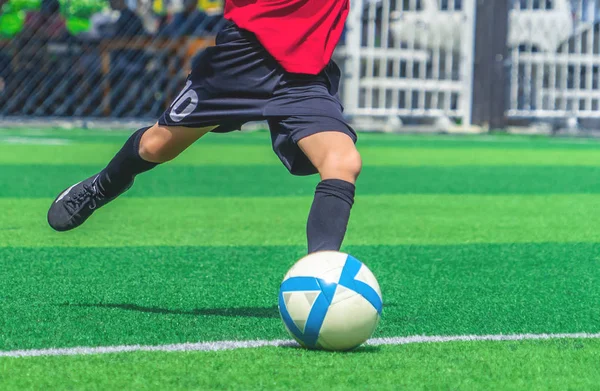 El chico de fútbol está entrenando pateando la pelota en el campo de entrenamiento de fútbol. — Foto de Stock