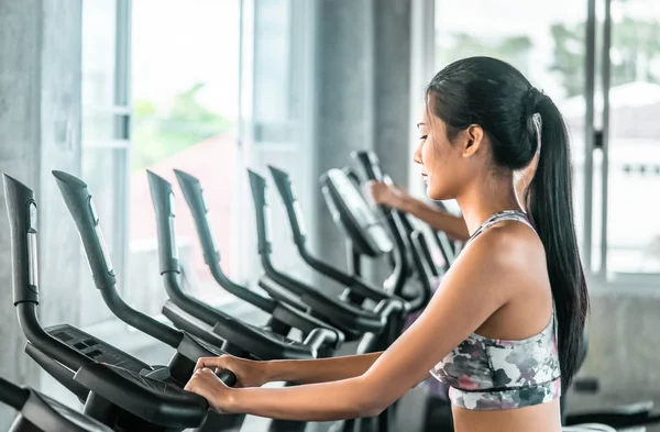 Mujer está trabajando en la máquina escaladora Step en el gimnasio de fitness para — Foto de Stock