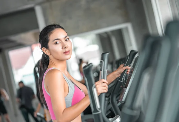 Female in pink sport wear is working out on Step climber machine