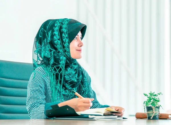 Sudeste Asiático mulher islâmica está escrevendo em um boo — Fotografia de Stock