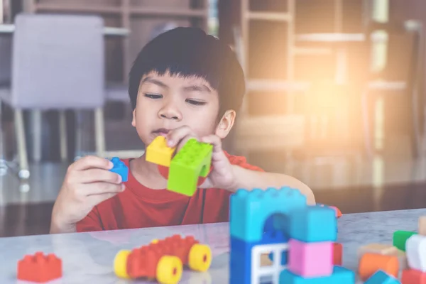 Szczęśliwy chłopiec układania zabawki bloki na pokój dzienny dla edukacji t — Zdjęcie stockowe