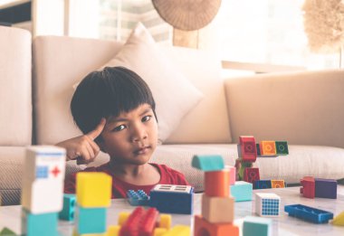 Küçük çocuk oyuncak blok oluşturma rağmen düşünme