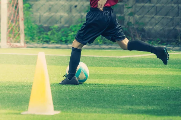 Futebol menino está treinando chutando a bola no campo de treinamento de futebol — Fotografia de Stock