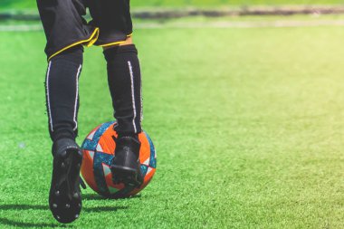 Çocuk ayakları bir sahada futbol topu salya