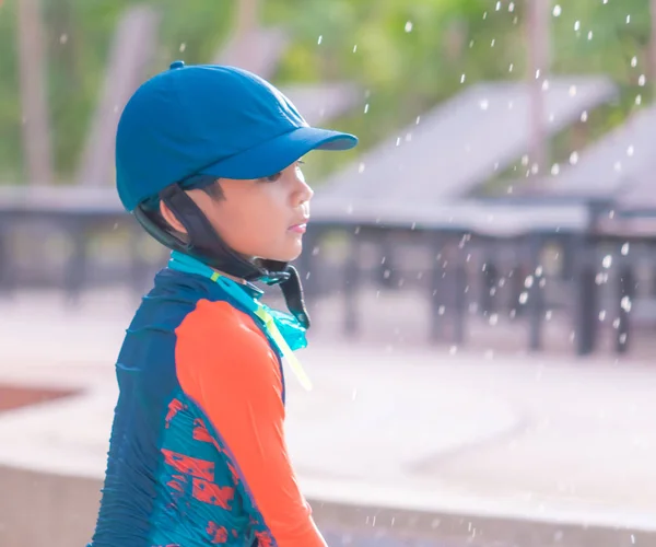 Menino com chapéu azul e terno laranja está brincando na natação — Fotografia de Stock