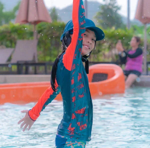 Menina está salpicando água na piscina — Fotografia de Stock