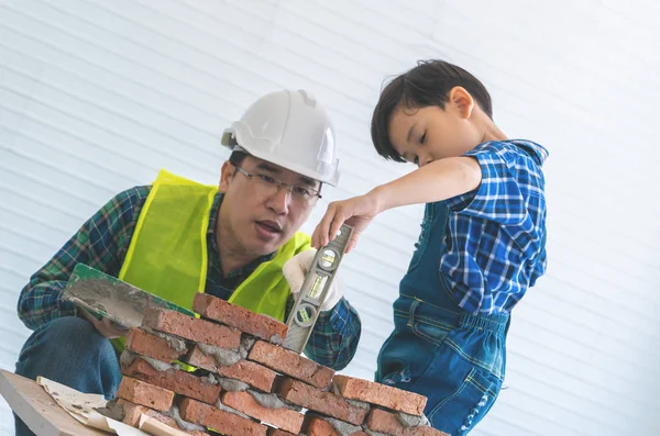 Küçük çocuk tuğla işini kendi yapısından öğreniyor.
