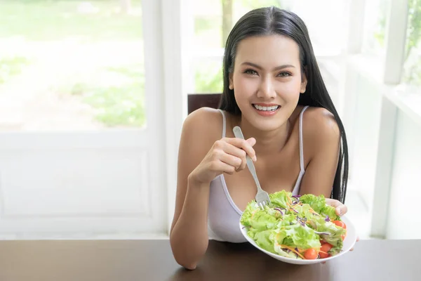 Mujer joven atractiva saludable está comiendo ensalada verde para una vida saludable —  Fotos de Stock