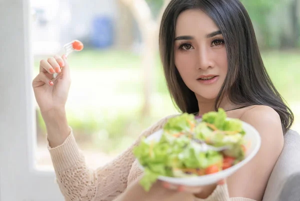 女性は家で食べるサラダの大きなプレートを保持しています — ストック写真