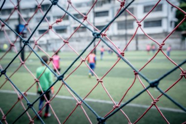Çocuk futbol antrenmanını arka planda yapıyor.