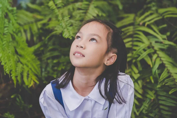 Estudante asiático feliz sentado no jardim verde — Fotografia de Stock