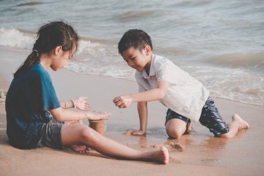 Çocuklar çevresel kirlilik için sahildeki çöpleri temizliyor.
