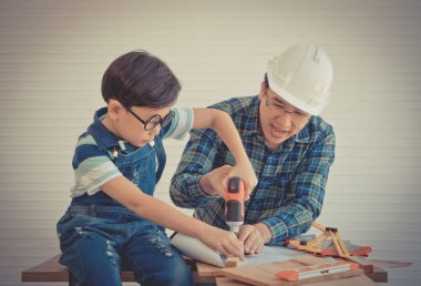Küçük Çocuk ahşap üzerinde çalışmayı öğreniyor ve onun sayesinde inşaatçı oluyor.