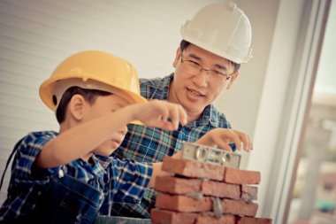 Küçük çocuk tuğla işini kendi yapısından öğreniyor.