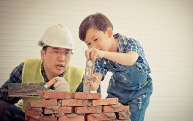 Küçük çocuk tuğla işini kendi yapısından öğreniyor.