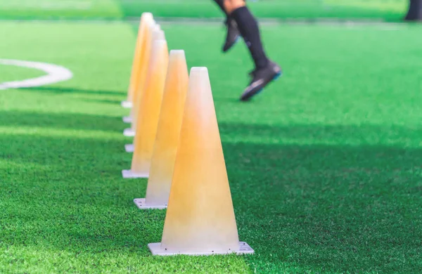 Kinderfüße mit Fußballschuhen trainieren auf Trainingskegel auf Socken — Stockfoto