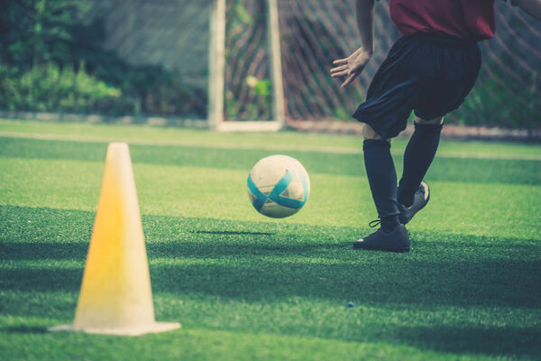 Soccer boy is training kicking the ball in soccer training field