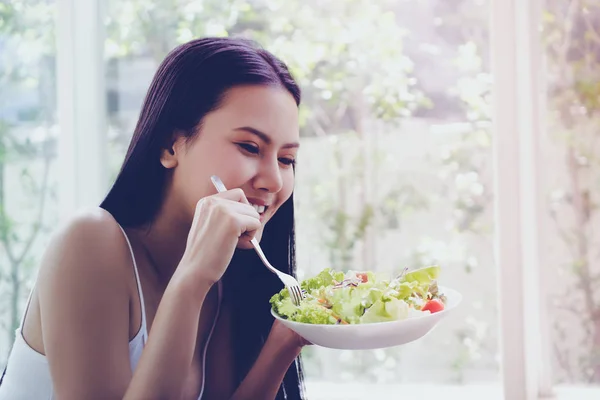 Mulher está desfrutando de salada vegetal como seu pequeno-almoço monring em ho — Fotografia de Stock
