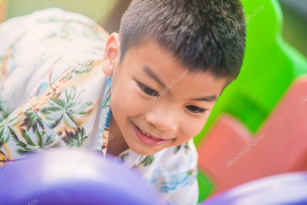 Healthy Asian boy in the colorful plastic playground in public park for healthy and hapyy child concept