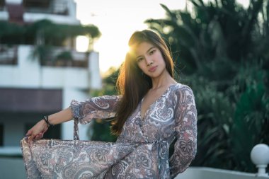 Güzel Asyalı kadın, özgürlük ve rahatlatıcı konsept için gün batımı hafif siluetiyle dans ediyor..