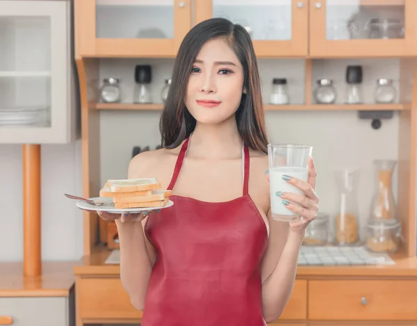 Happy Seductive girlfriend wearing only apron is preparing breakfast for her boyfriend.