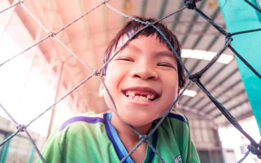 Çocuklar için futbol antrenmanı sahasında gülümseyen mutlu Asyalı çocuk eğlence yaşam tarzı konsepti.