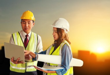 İki müteahhit mühendis erkek ve kadın Sunset ile belge fabrikasında tartışıyorlar..