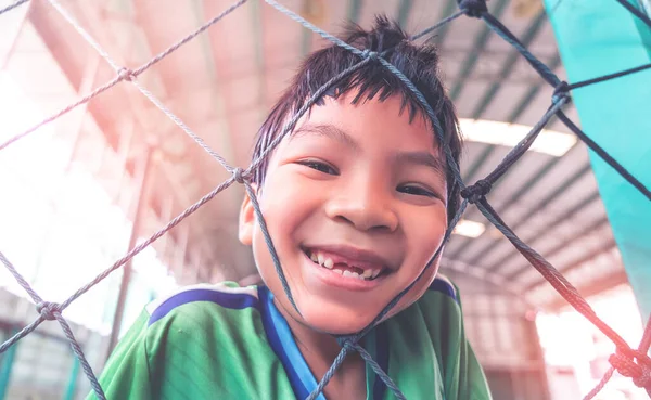 Çocuklar için futbol antrenmanı sahasında gülümseyen mutlu Asyalı çocuk eğlence yaşam tarzı konsepti.