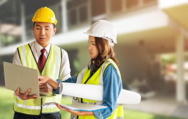 İki müteahhit mühendis erkek ve kadın evle doküman fabrikasında arka plan üzerinde tartışıyorlar..