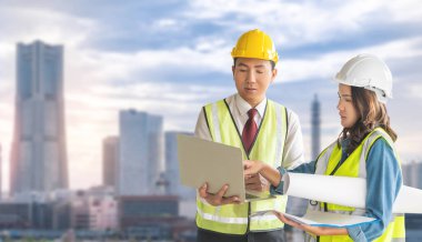 İki mühendis erkek ve kadın, arka planda Yokohama City Modern Binası ile doküman fabrikası üzerinde tartışıyorlar..