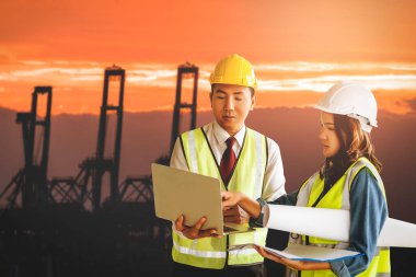 İki takım mühendisi nakliye işi konsepti için deniz limanındaki vinç limanında bekliyor..