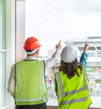 İki inşaat mühendisi ve bir kadın nakliye şantiyesi hakkında konuşuyor.