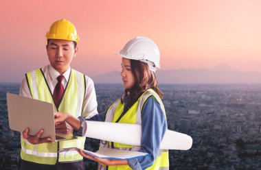 İki müteahhit mühendis erkek ve kadın, arka planda Tokyo City ile belge fabrikasında görüşüyorlar..