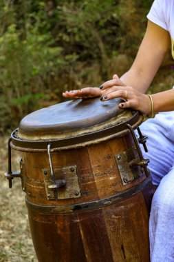 Woman percussionist hands playing a drum called atabaque during brazilian folk music performance  clipart