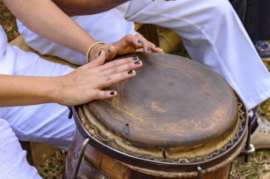 Young woman percussionist hands playing a drum called atabaque during brazilian folk music performance  clipart