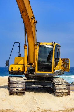 Sarı Ekskavatör kabin ve kol üzerinde kum Beach deki güneşli bir gün