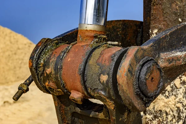 Kumsalda buldozer paslı ve kirli petrol dişli takımı detay