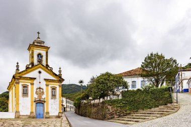 Antik tarihi kilise, houases ve sokakları arka planda karanlık bulutlar içinde Brezilya tarihi şehir, Ouro Preto'daki