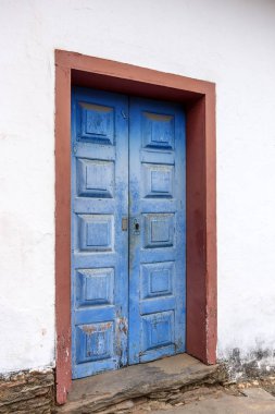 Eski ve yaşlı mavi tarihi kilise ahşap kapı Sabara, Minas Gerais paslı metal parçası ile şehir içinde.