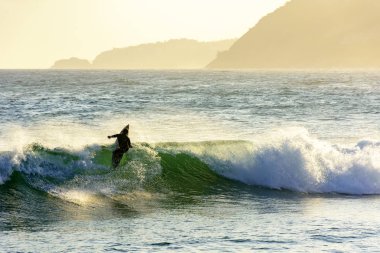 Sahilde, Ipanema, Rio de Janeiro günbatımı sırasında deniz sörfçü silüeti