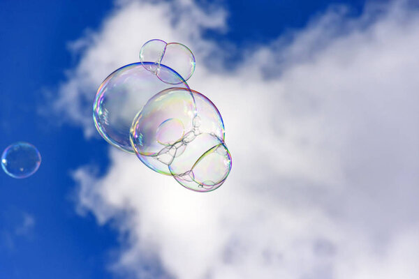 Soap bubbles with their colors and transparencies floating in the blue sky
