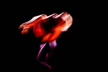 Çağdaş dans gösterilerinde koyu arkaplanlı dansçıların bulanık hareketleri
