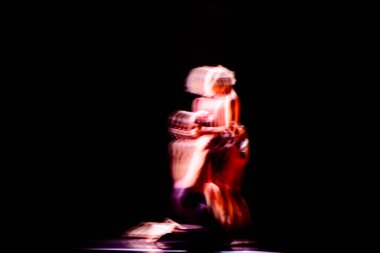 Çağdaş dans gösterilerinde koyu arkaplanlı dansçıların bulanık hareketleri