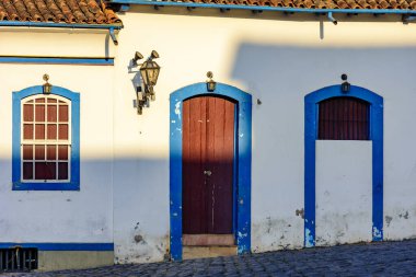 Ouro Preto, Minas Gerais 'deki sömürge mimarisinde mavi pencereli ve kapılı eski evin ön cephesi