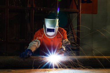 Fabrikada çalışan kaynakçılar metal üretiyorlar.