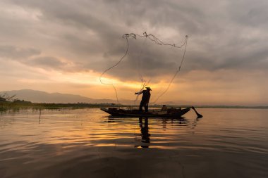 Geleneksel balık avcılarının gün batımında siluetleri